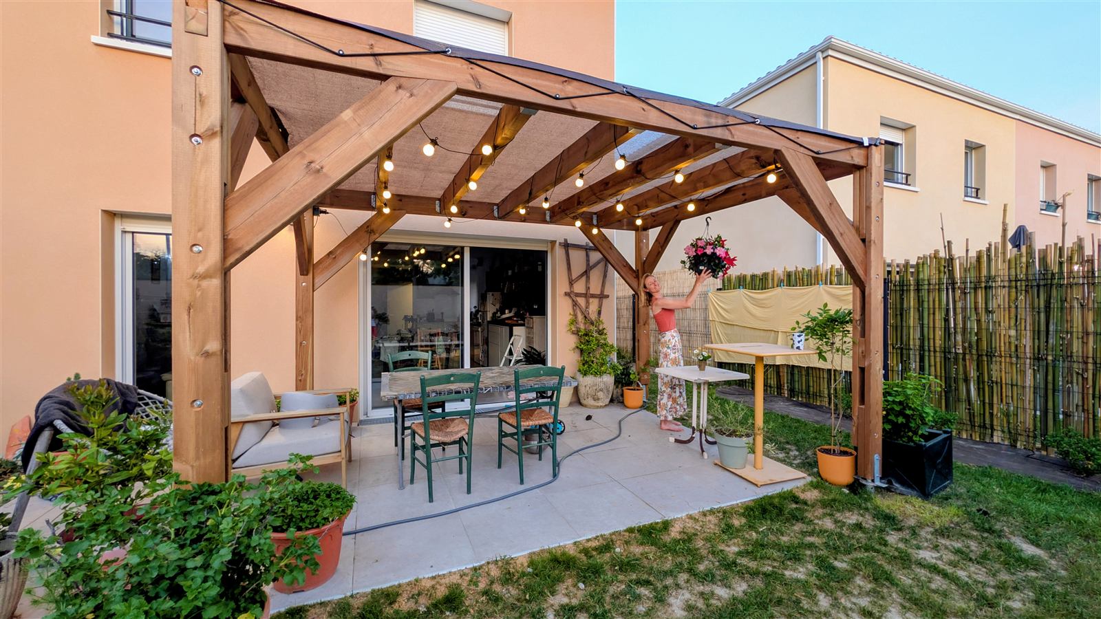 Pergola en bois construite contre une maison